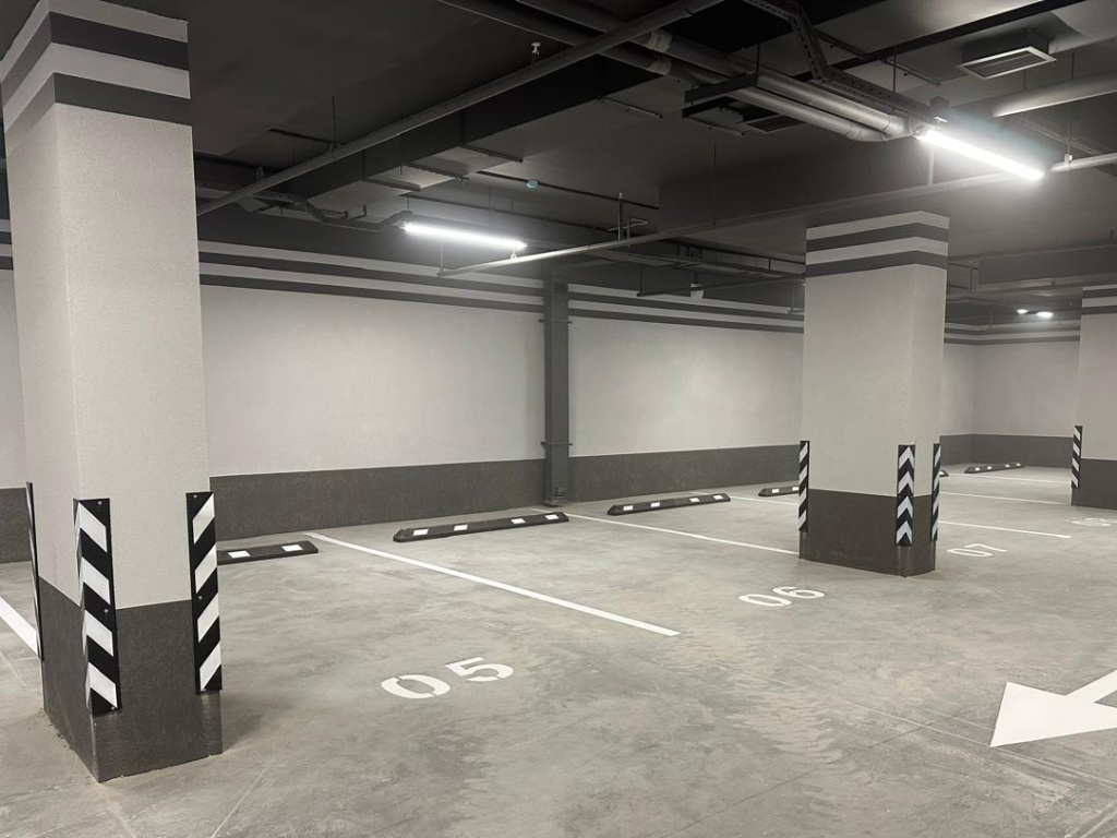 Подземная парковка, оснащенная оборудованием с белыми светоотражателями