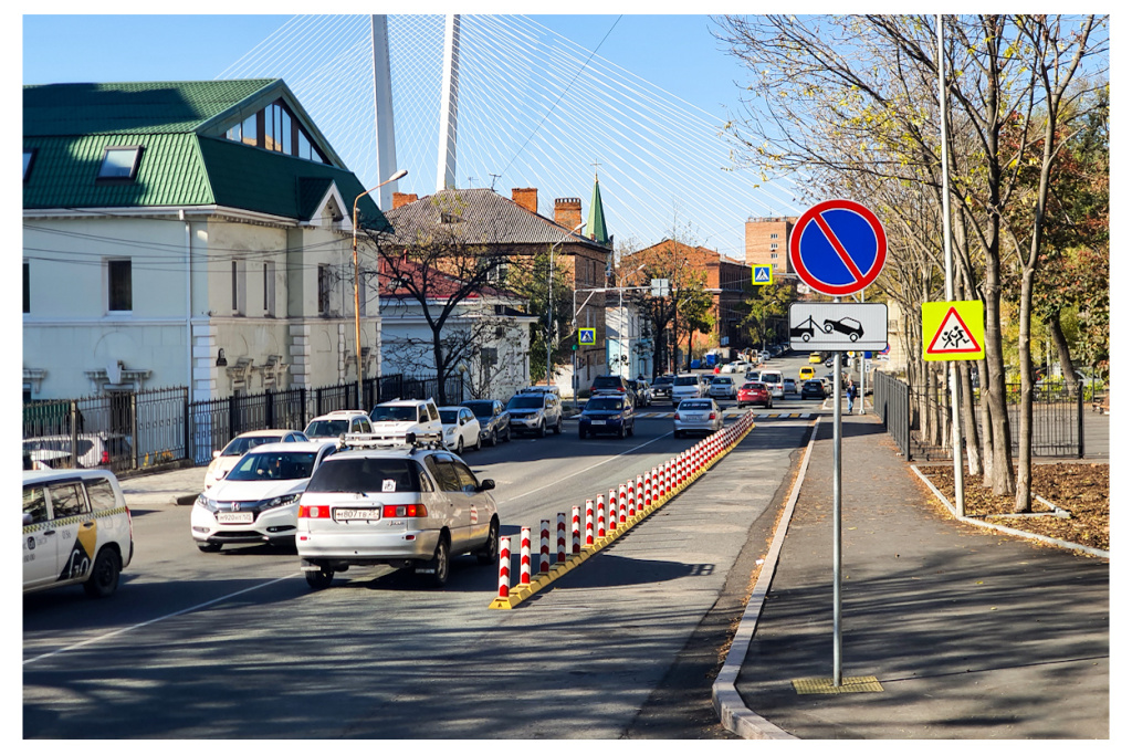Участок возле тротуара, ограниченный дорожными делиниаторами с флажками