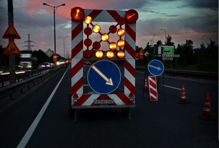 Зона ремонта дороги, обозначенная ограждающим прицепом с фонарями для видимости в темное время суток Зона ремонта дороги, обозначенная ограждающим прицепом с фонарями для видимости в темное время суток