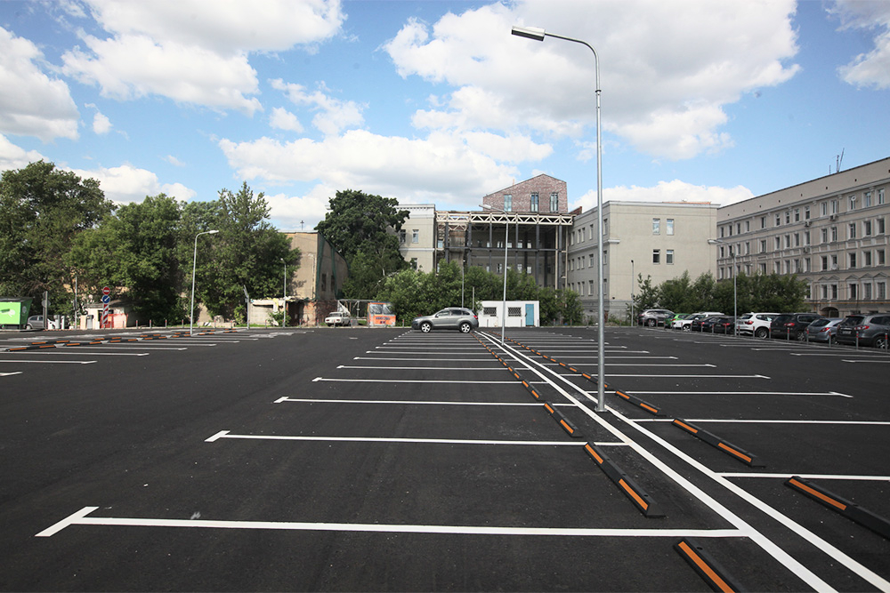 Уличная автостоянка, оборудованная разметкой и колесоотбойниками Уличная автостоянка, оборудованная разметкой и колесоотбойниками