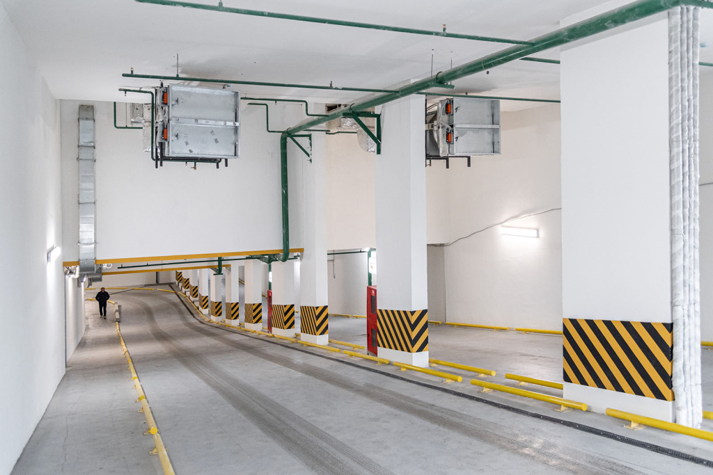 Отбойники для колес, играющие роль делиниаторов на выезде из подземной парковки