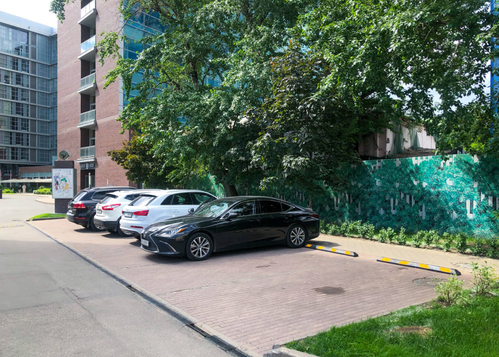 Парковка возле жилого комплекса, оснащенная колесоотбойниками